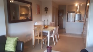 A living room with a dining area, a kitchen, and a staircase.