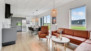A modern living room with a leather sofa, a dining area with a table and chairs, and a kitchen with a coffee machine. - Pet friendly home in Løgstrup with WiFi (Løgstrup)
