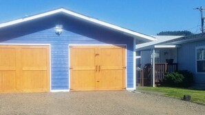 A two-car garage attached to a house with a blue exterior and a white roof. - North Sunrise Studio - Retreat in Forks (Forks)