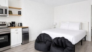 A modern hotel room with a bed, a kitchenette, and two black bean bags. - North Sunrise Studio - Retreat in Forks (Forks)