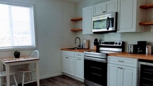 A compact kitchen with white cabinets, a microwave, a stove, and a toaster. - North Sunrise Studio - Retreat in Forks (Forks)