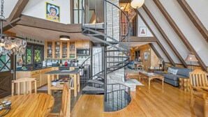 Spazioso loft con scala a chiocciola centrale, pavimento in legno e angolo cottura con elettrodomestici moderni.