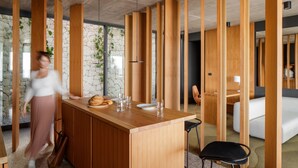 Una cocina moderna con una isla de madera, pared de piedra y vistas al exterior.