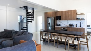 A modern kitchen with a central island, wooden cabinets, and stainless steel appliances. - Lovedale Abode 13 bedrooms with heated pool & Acres (Lovedale)
