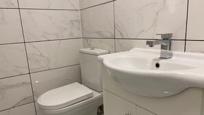 Un bagno con servizi igienici, lavandino e piastrelle in marmo.