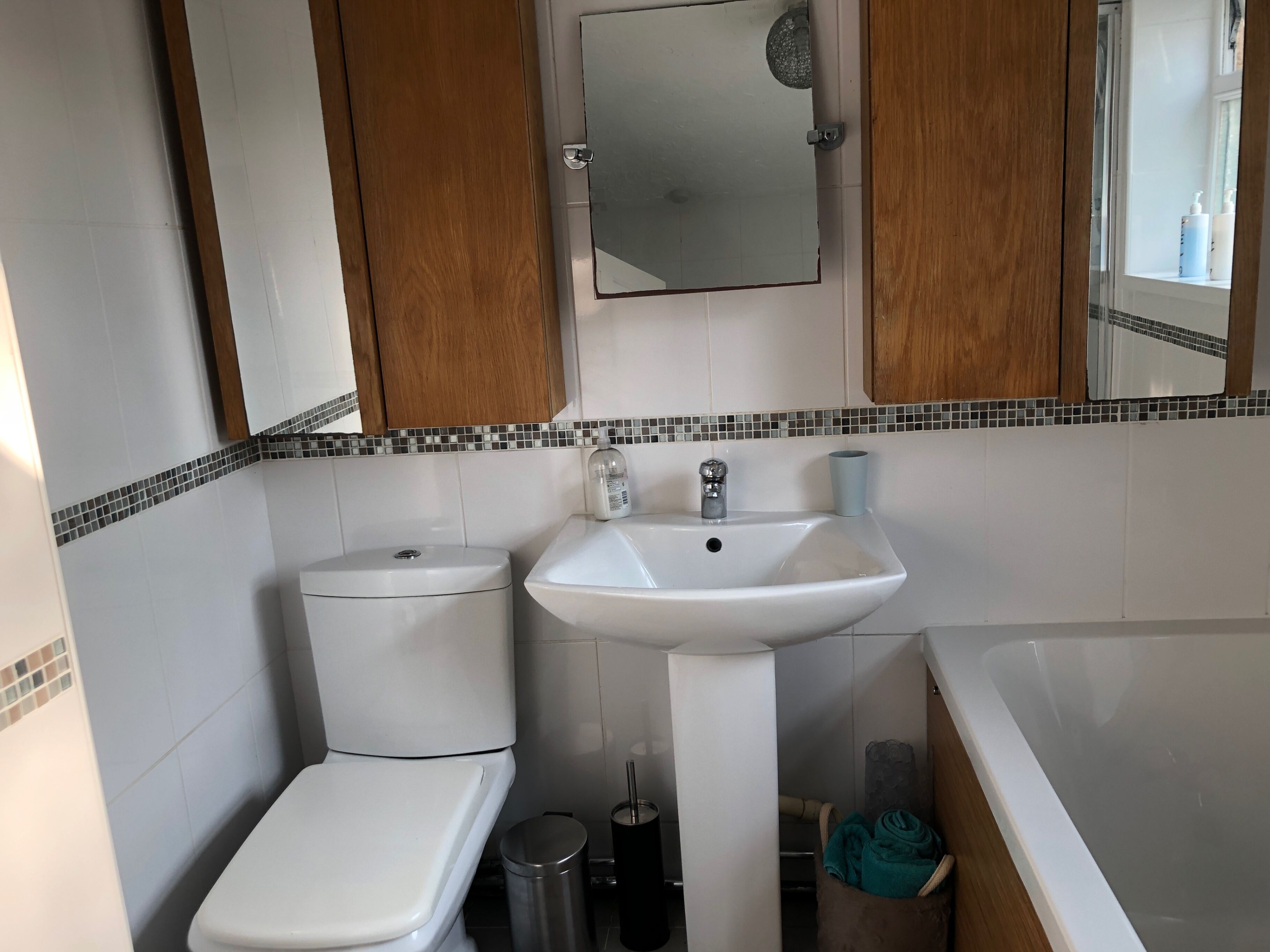 A bathroom with a toilet, sink, and bathtub.