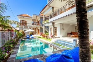 A modern hotel with a swimming pool, outdoor seating, and a balcony with a view. - D'Canggu Homestay (Canggu)