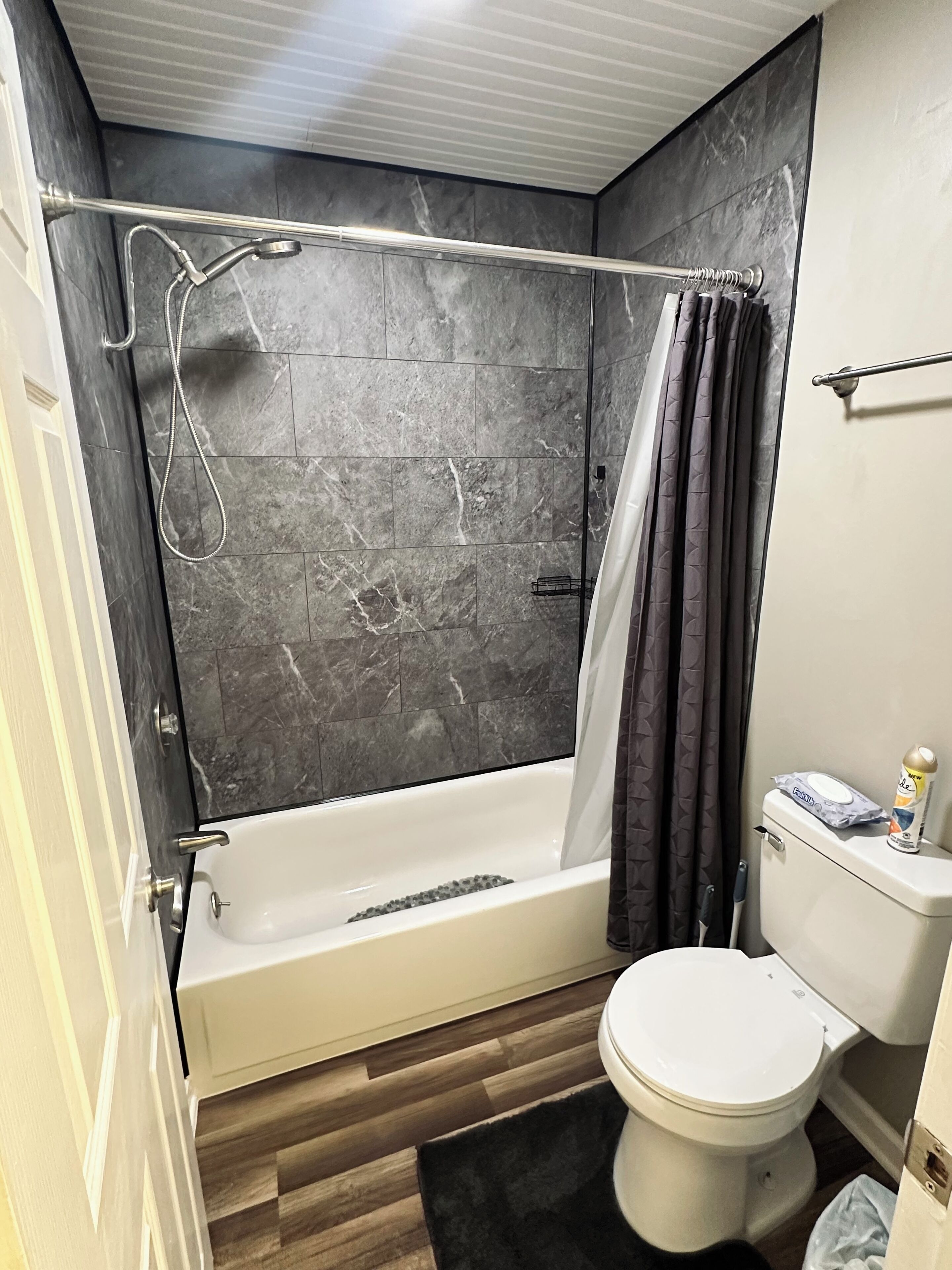 Un baño con bañera, inodoro y cortina de ducha.