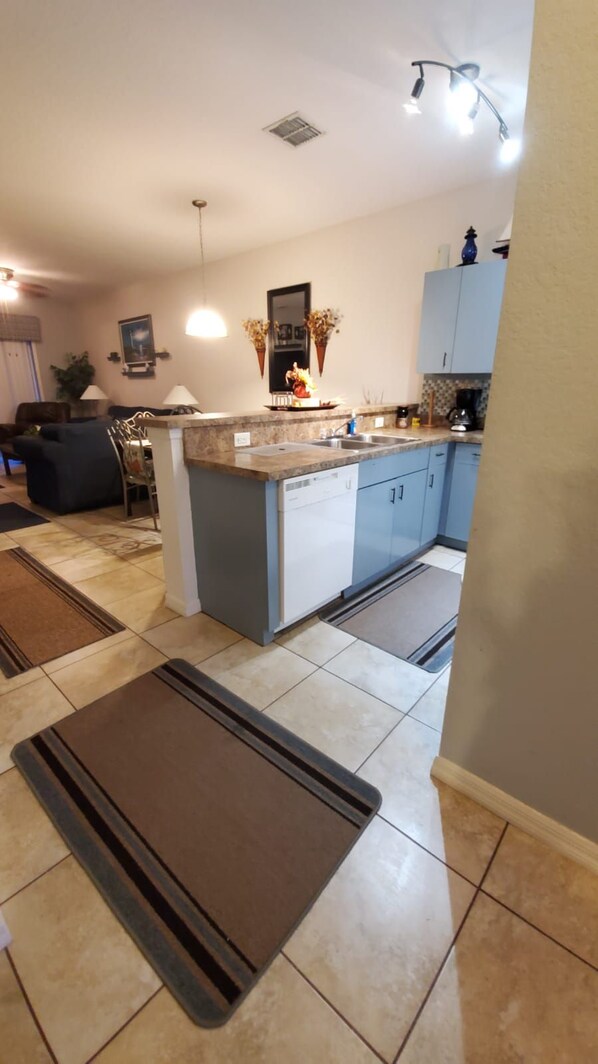 A modern kitchen with a central island, built-in cabinets, and a dining area with a sofa and chairs.