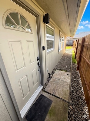 A house with a white door, a small porch, and a wooden fence.