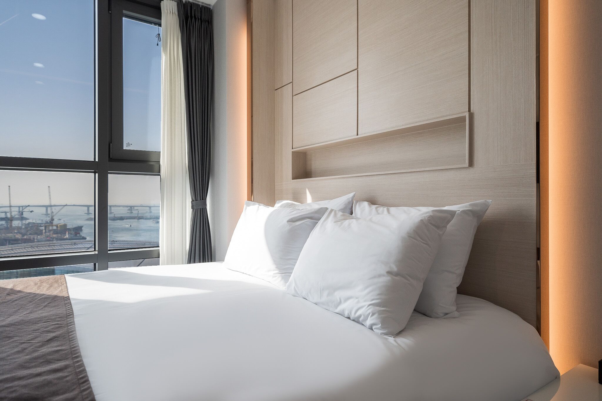 Une chambre d’hôtel dotée d’un grand lit, offrant une vue sur la mer et présentant un design moderne.