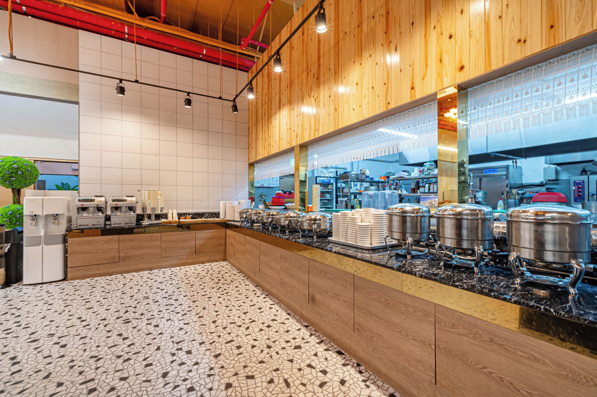 A modern kitchen with wooden paneling, a tiled floor, and stainless steel appliances.