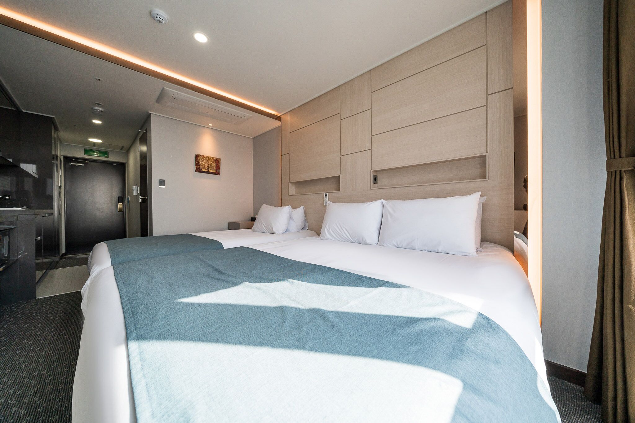 Una habitación de hotel con una cama grande, un escritorio y un armario.