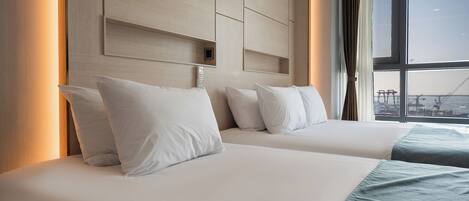 A hotel room with two beds, a large window with a view of the city, and a modern headboard.