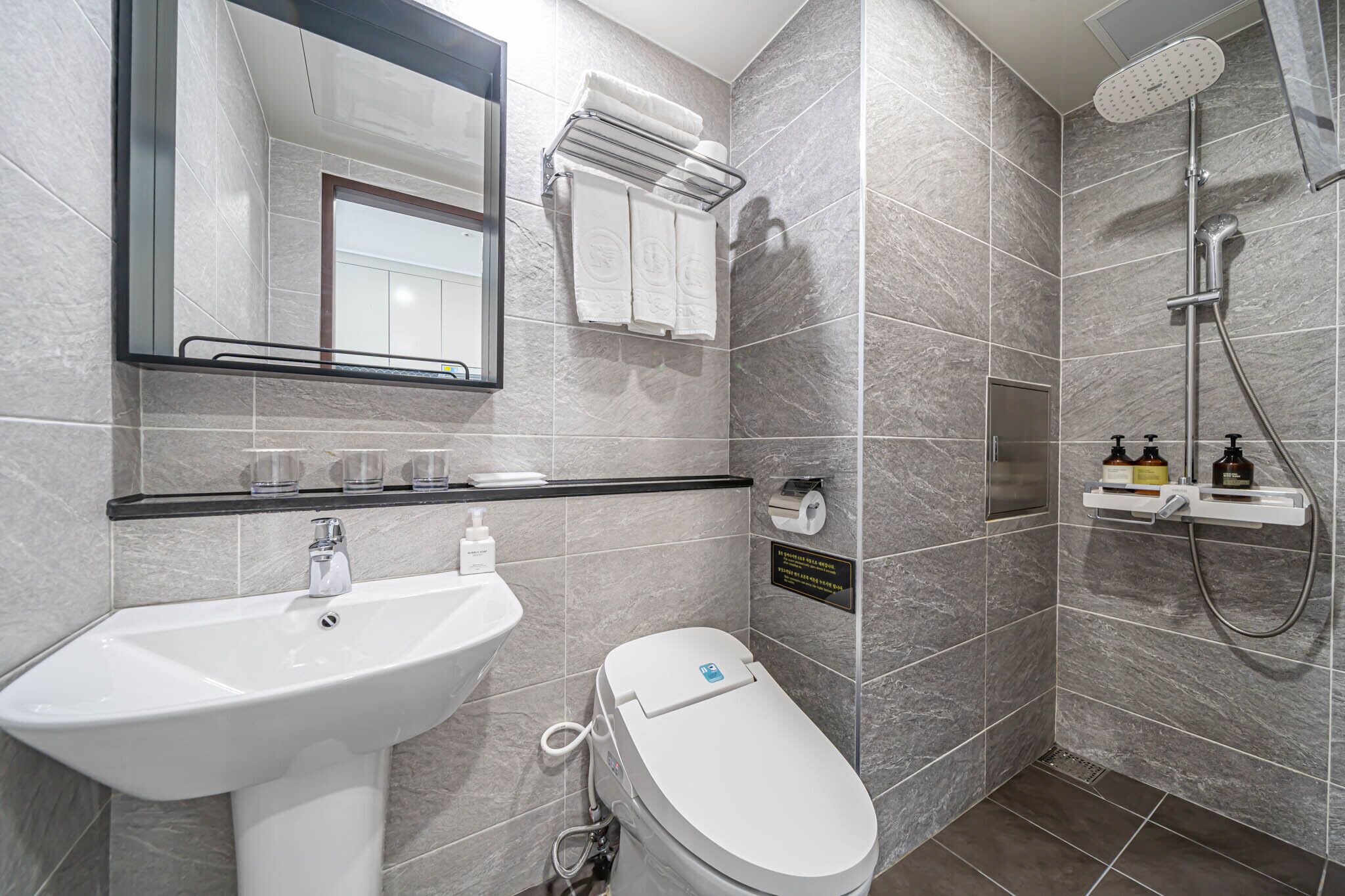 A modern bathroom with a sink, toilet, and shower.