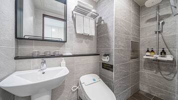 A modern bathroom with a sink, toilet, and shower.