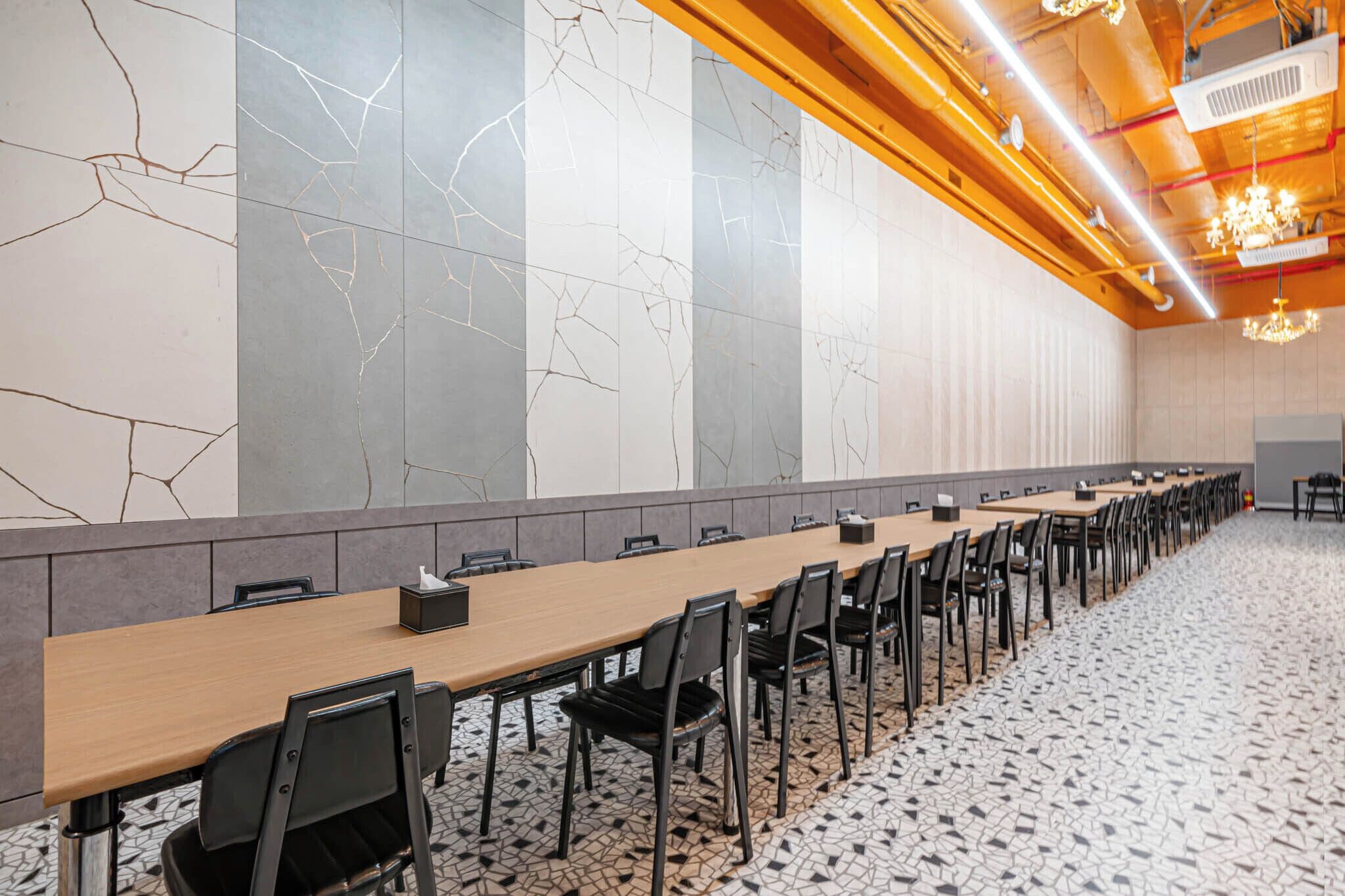 A conference room with a long table, chairs, and a tiled floor.