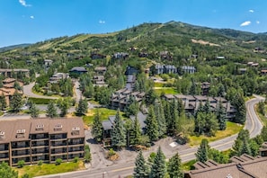 A residential area with multiple buildings, roads, and a hilly landscape in the background. - Steps to Ski-Steps to HotTub/Town Bus-Wood Stove (Steamboat Springs)