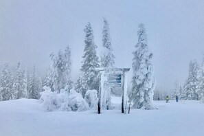 A snow-covered landscape with a signpost indicating directions to various locations.