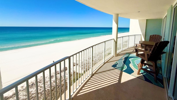 Ein Balkon mit Blick auf Strand und Meer.