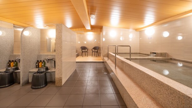 Ein modernes Spa mit einer großen Whirlwanne, einer Sauna und einem Duschbereich mit Bänken.