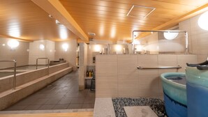 Ein Wellnessbereich mit einer Steinsitzbank, einer Whirlwanne und einem gefliesten Boden.