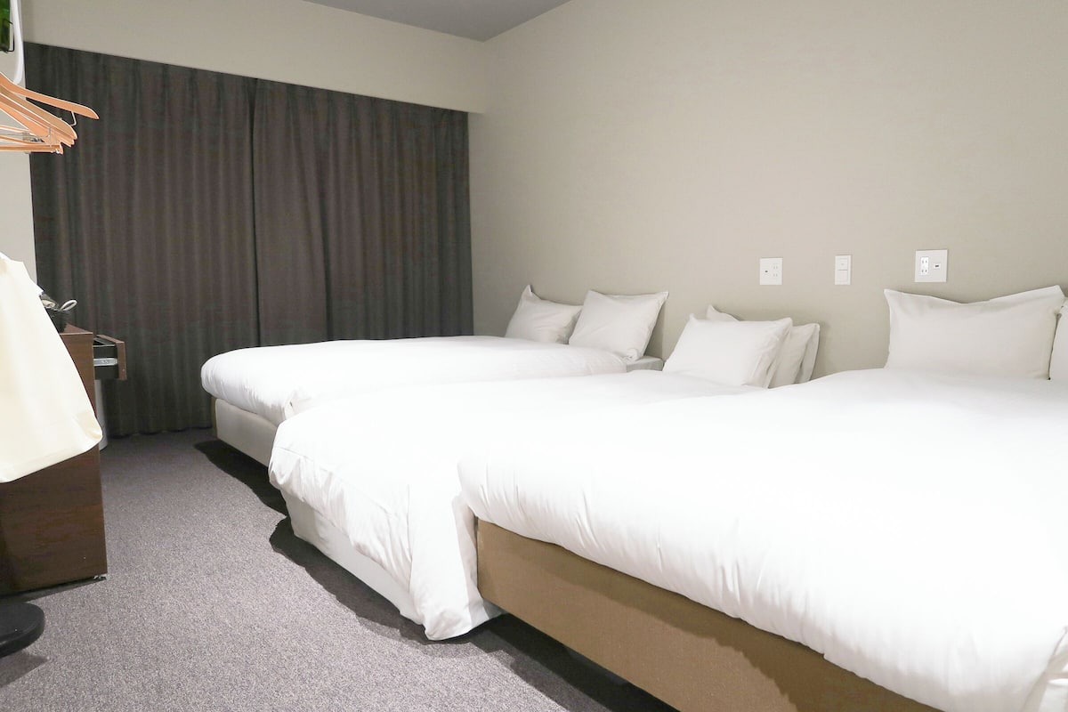 Habitación triple económica | Ropa de cama de alta calidad, edredón, escritorio y cortinas blackout