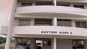 A multi-story building with balconies and a parking area. - License to Chill Apartment (Larnaca)
