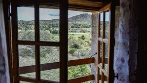 A view through a window with a wooden frame, revealing a landscape with hills and greenery. - Magnificent private Mas Ardechois with swimming pool (Labastide-de-Virac)