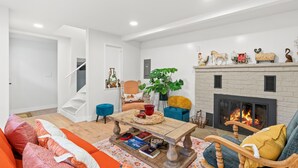 Un salon moderne avec une cheminée, un escalier et un coin salon confortable.