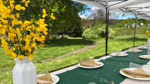 Enjoy a meal under the stars in our serene outdoor dining area, complete with a beautifully set table and a lovely floral centerpiece.