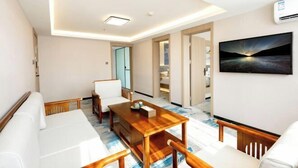 A modern hotel room with a wooden dining table, white sofa, and a large window. - JiHe Hotel (Jiaozuo Railway Station Puji Road) (Jiaozuo)