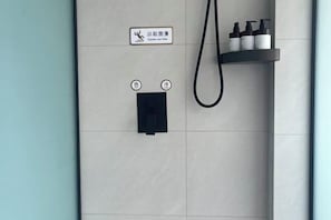 A bathroom with a towel rack, a shower control panel, and a shelf with toiletries. - JiHe Hotel (Jiaozuo Railway Station Puji Road) (Jiaozuo)