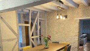 Ein Essbereich mit einem Holztisch, gelben und blauen Stühlen und einer Vase mit Blumen.