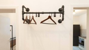 A hallway with a coat rack holding several hangers.