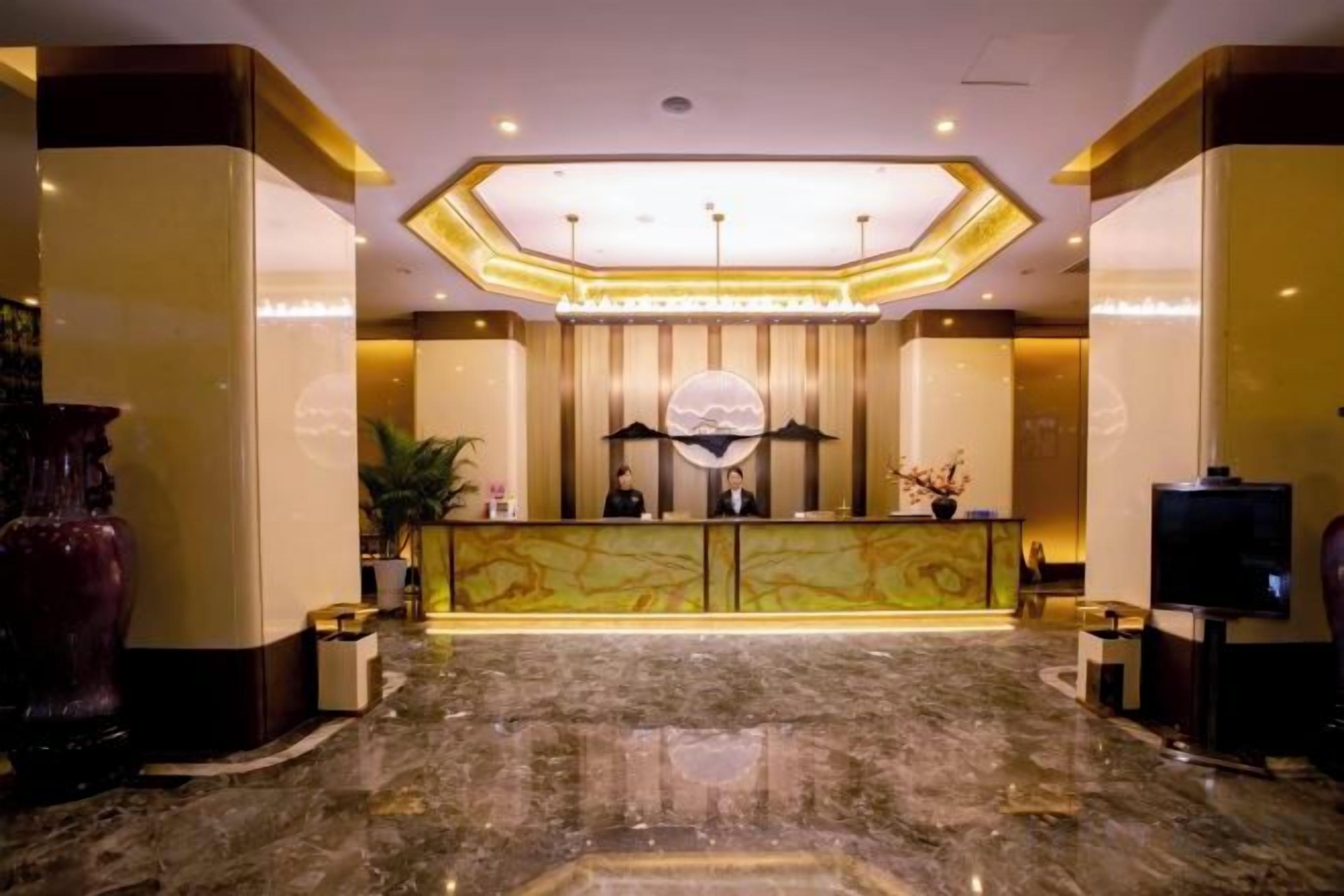 A hotel reception area with a marble floor, a reception desk, and a large decorative globe.