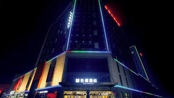 Un edificio de varios pisos con señalización iluminada y una entrada destacada.