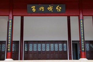 Entrada de un edificio chino tradicional con un letrero y ventanas de celosía de madera.