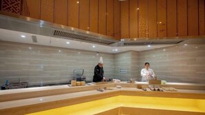 A hotel lobby with a central seating area, a reception desk, and a patterned wall. - Mingdu Hotel (Wuyang)