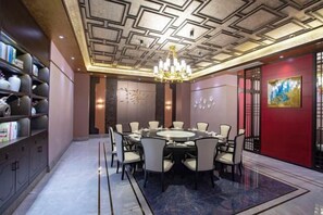 A dining area with a round table, chairs, and a chandelier. - Mingdu Hotel (Wuyang)