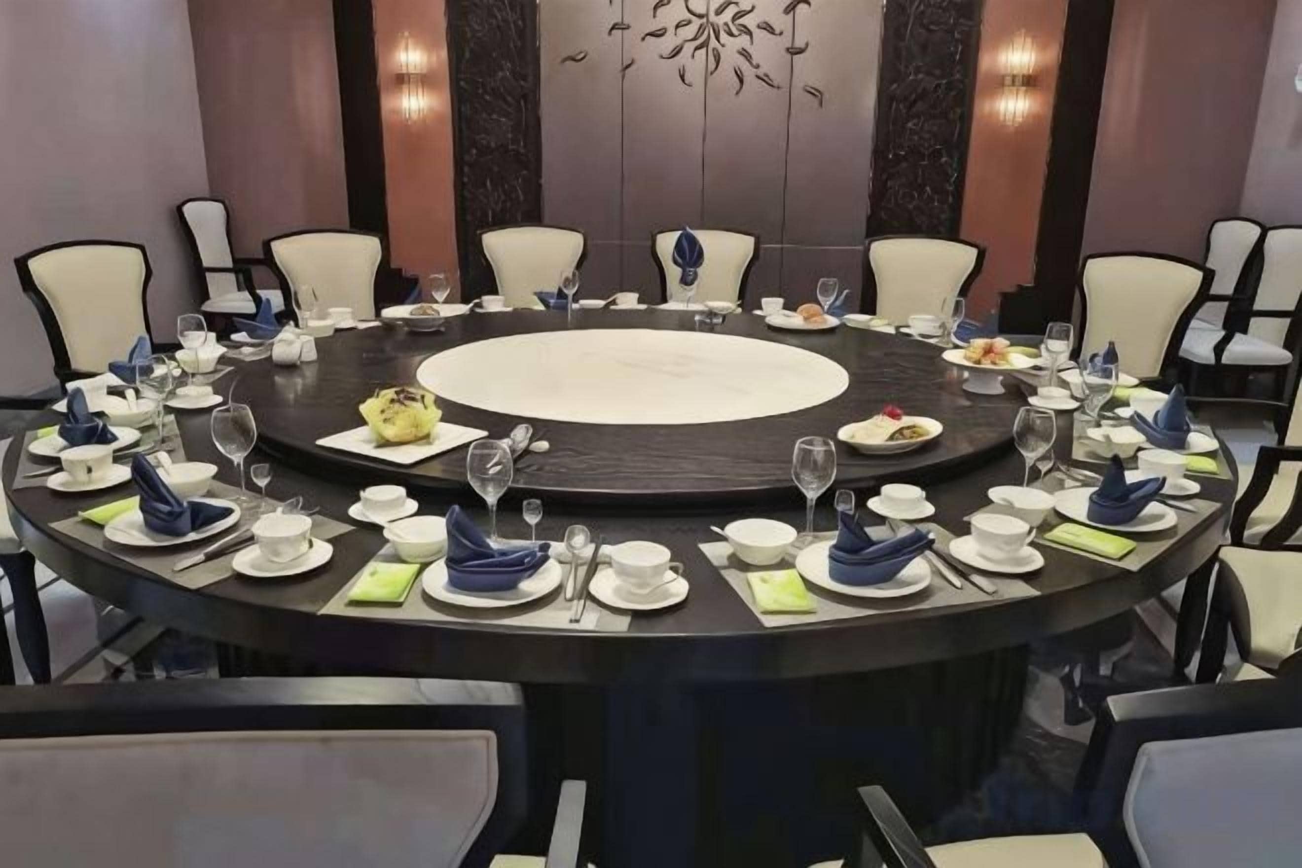 Una mesa redonda con sillas dispuestas para una comida.