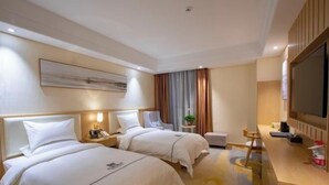 A hotel room with two beds, a desk, a chair, a TV, and a painting on the wall. - Mingdu Hotel (Wuyang)