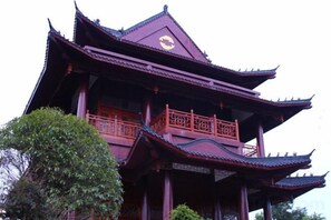 A multi-tiered pagoda-style building with ornate railings and a traditional roof. - Mingdu Hotel (Wuyang)