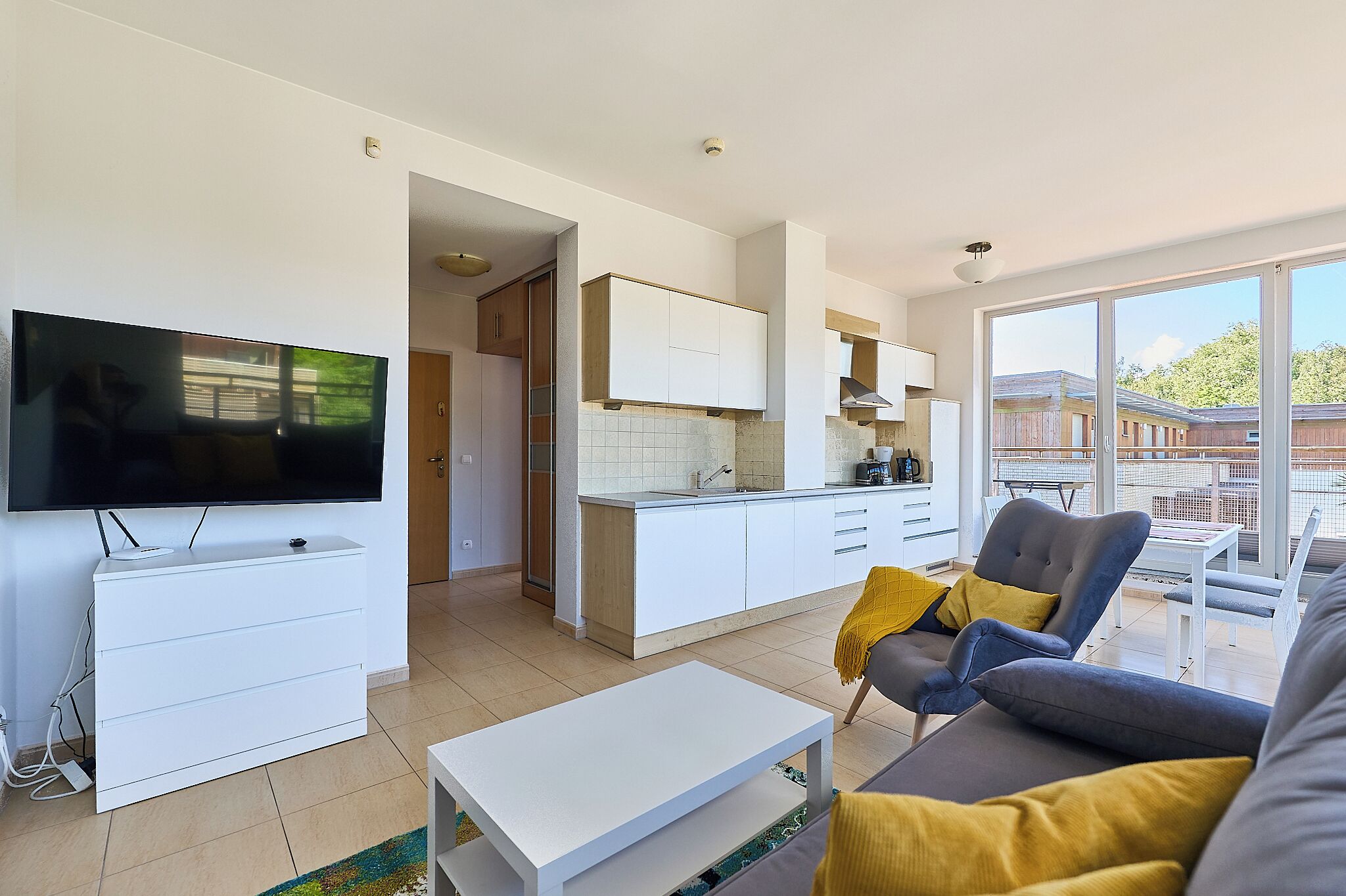 Un salon moderne avec un téléviseur à écran plat, un canapé et une table basse.