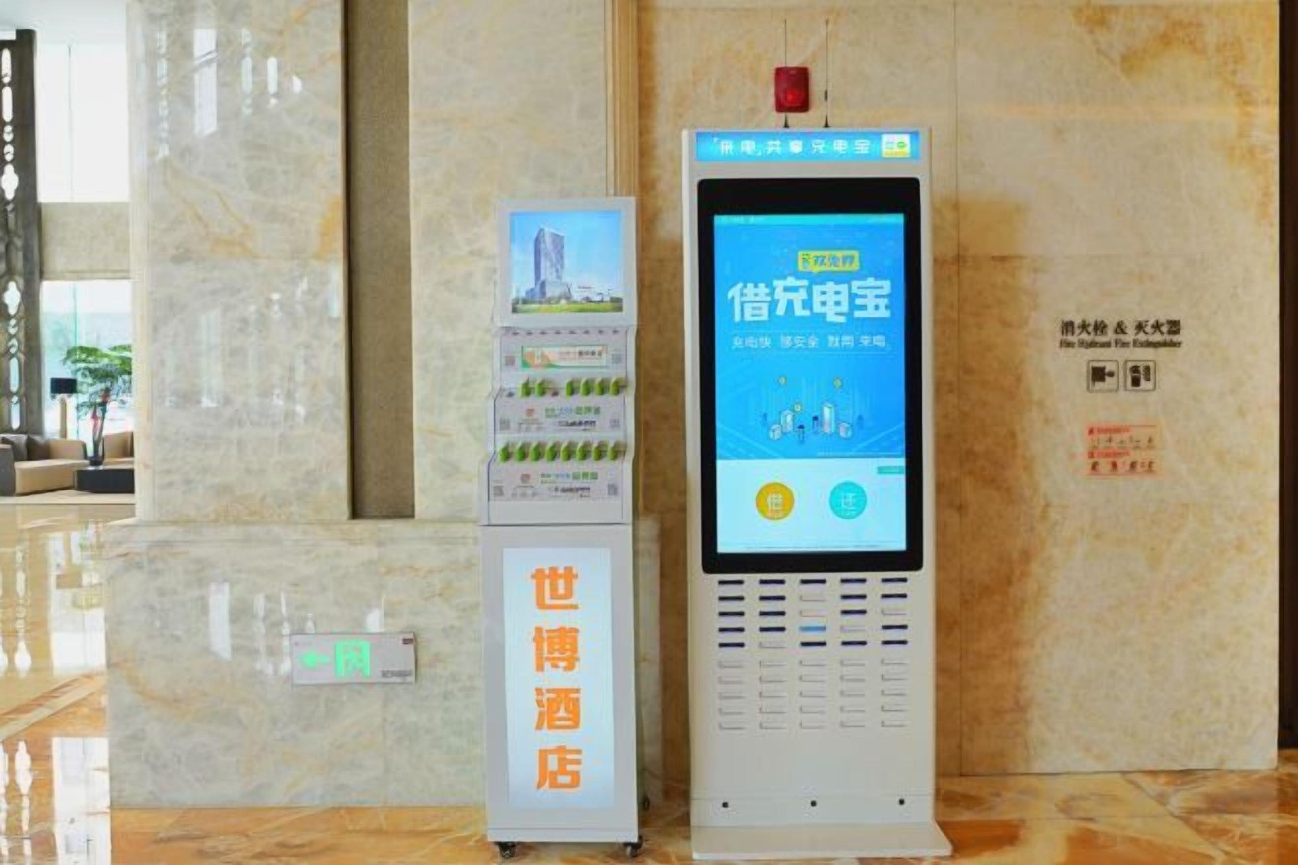 Ein Hotel-Empfangsbereich mit einer digitalen Kioskstation und einer Informationsausstellung.
