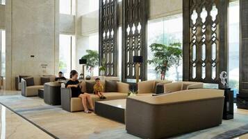 Un vestíbulo amplio con sofás modernos, una mesa de centro y paneles decorativos.
