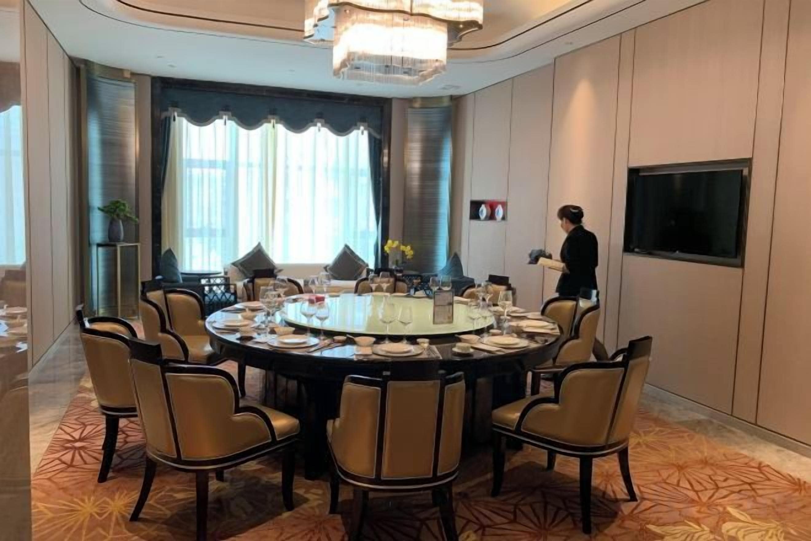 Une salle de conférence équipée d’une table ronde, de chaises et d’un écran de télévision.