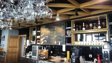 A bar area with a chalkboard menu, shelves with bottles, and a coffee machine.