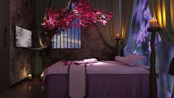 Relax in this serene bedroom with a large bed, a tree with blooming flowers, and a beautiful painting on the wall.