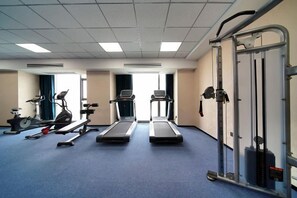 A fitness room with treadmills, elliptical machines, and a weight bench. - Expo Hotel (Tongxiang)